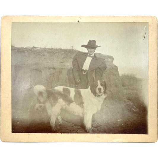 [Mounted photograph portrait of woman in Western American attire with Saint Bernard dog]