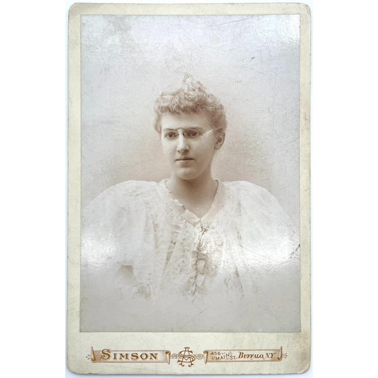 [Cabinet card of young woman in a dress wearing glasses in Buffalo, New York]